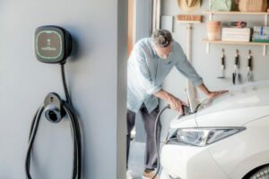 Man charging his car in his garage using the compact wall mounted Wallbox EV charger